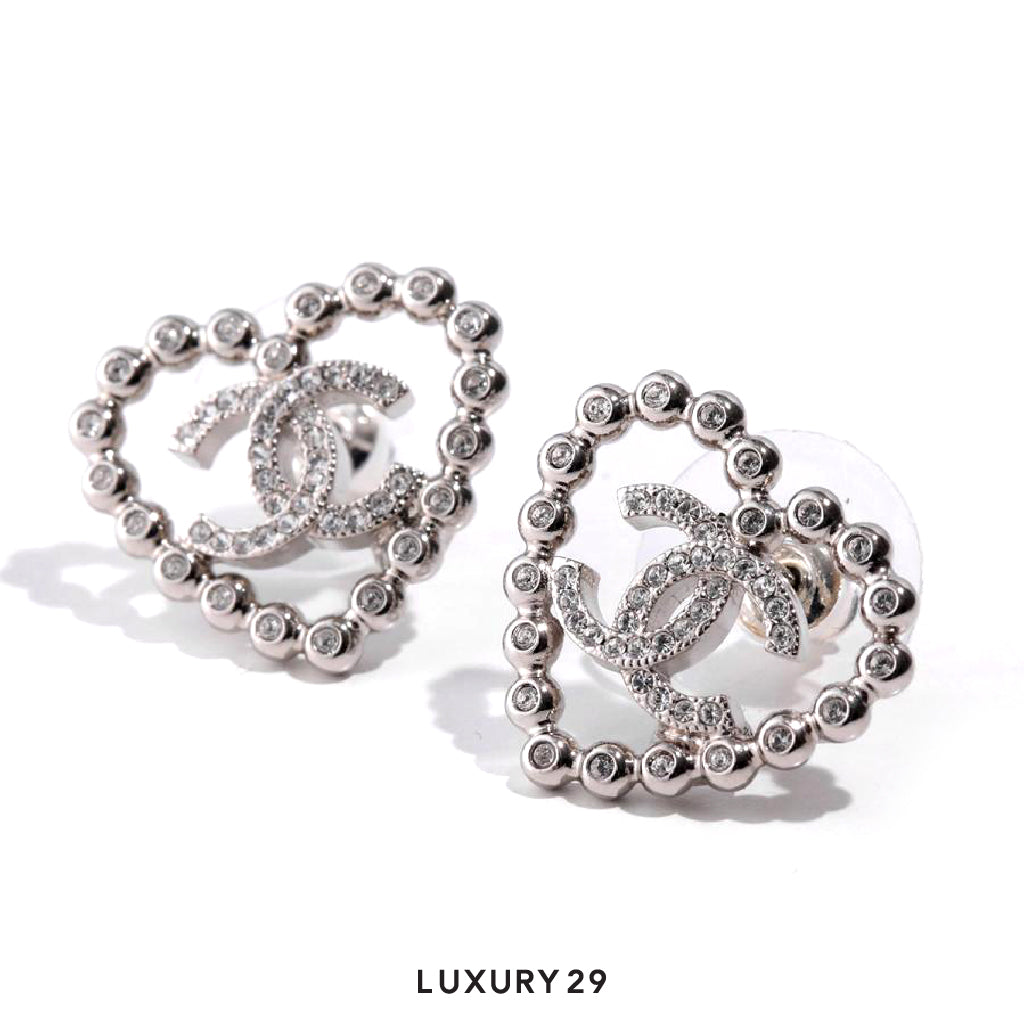 Silver earrings with intricate designs on a white background