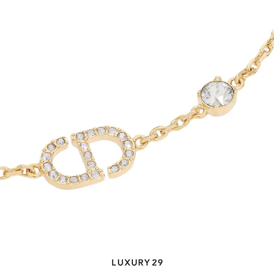 Gold bracelet with gemstones on a white background, labeled 'LUXURY 29'.