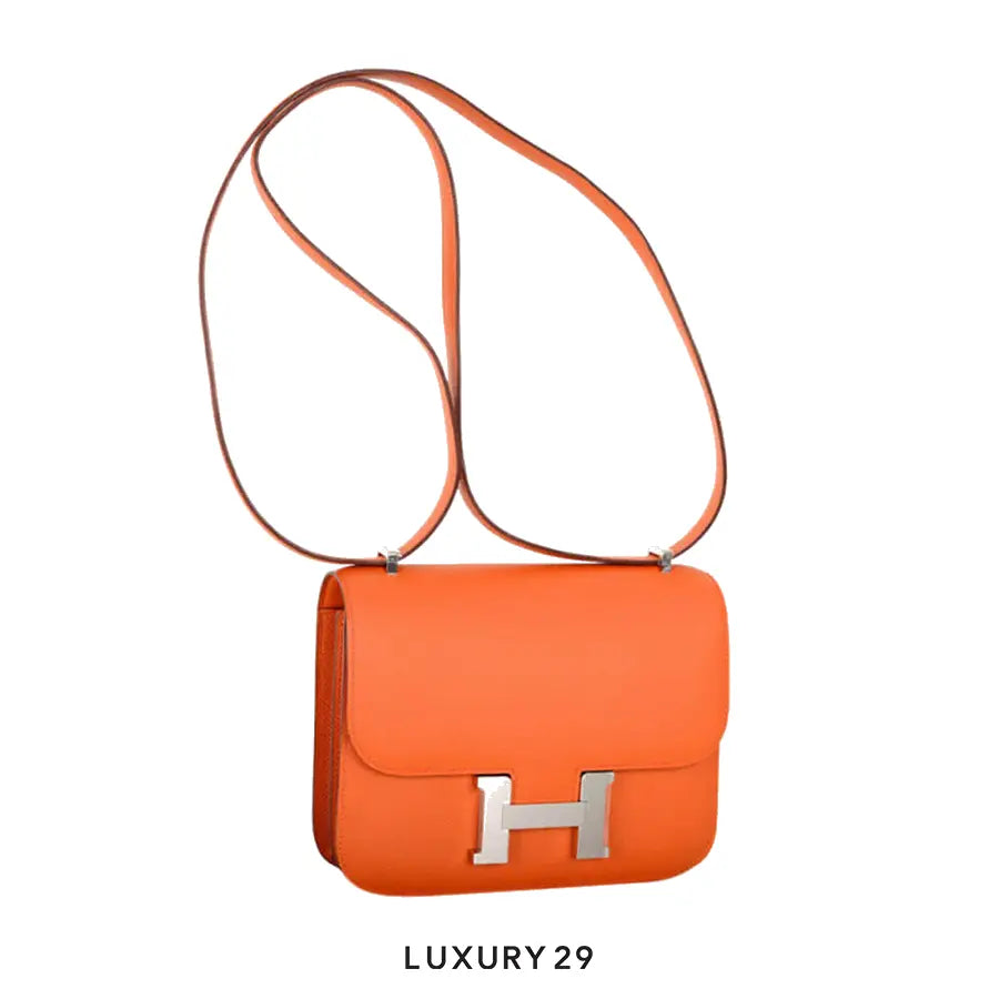 Orange handbag with a silver logo on a white background