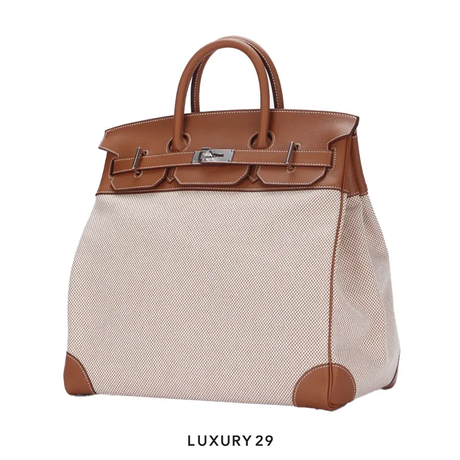 Luxury handbag with brown leather top and beige fabric body on a white background