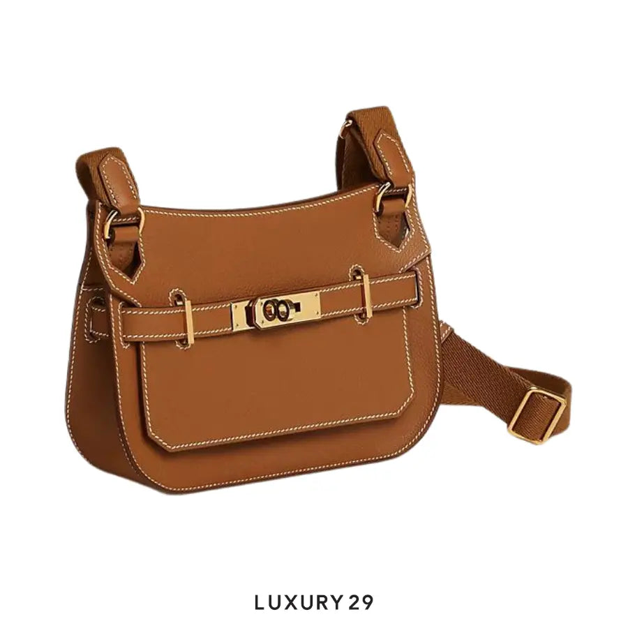 Brown leather handbag with gold accents on a white background