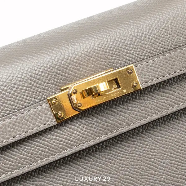Gray handbag with gold hardware featuring the Hermès logo.