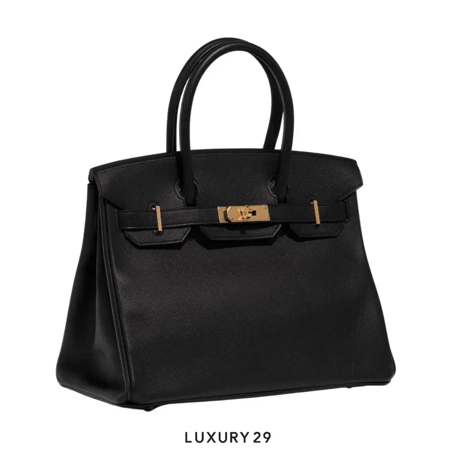 Black handbag with gold hardware on a white background