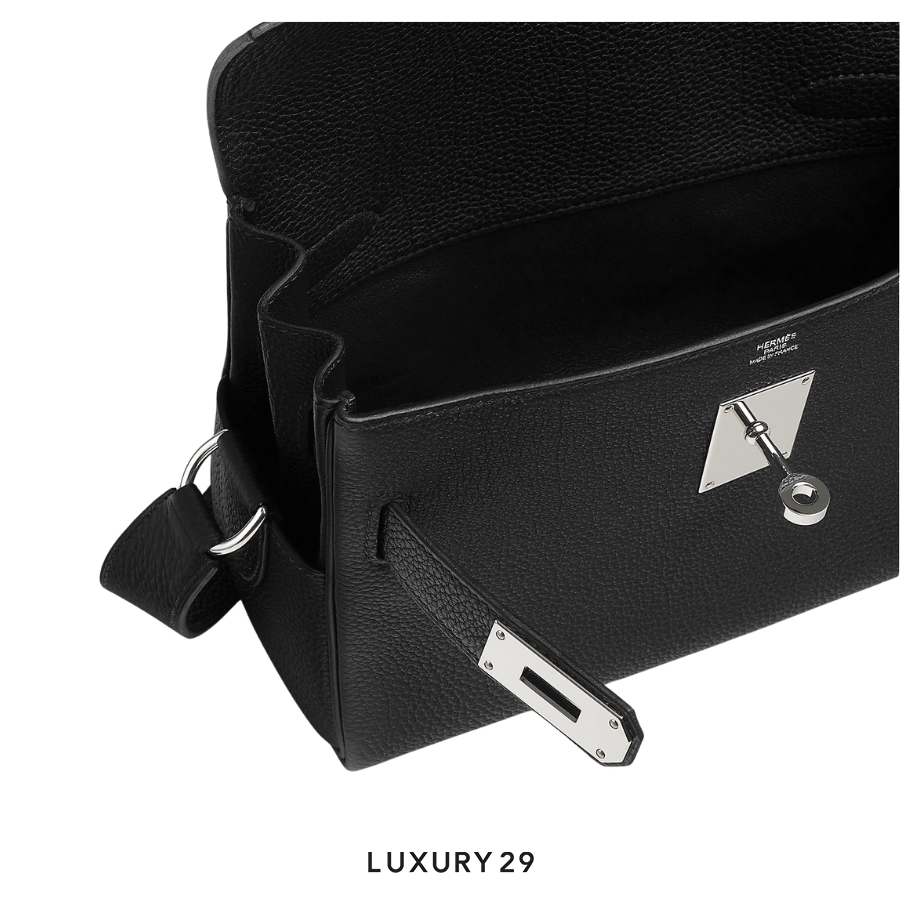 Black leather handbag with silver hardware on a white background