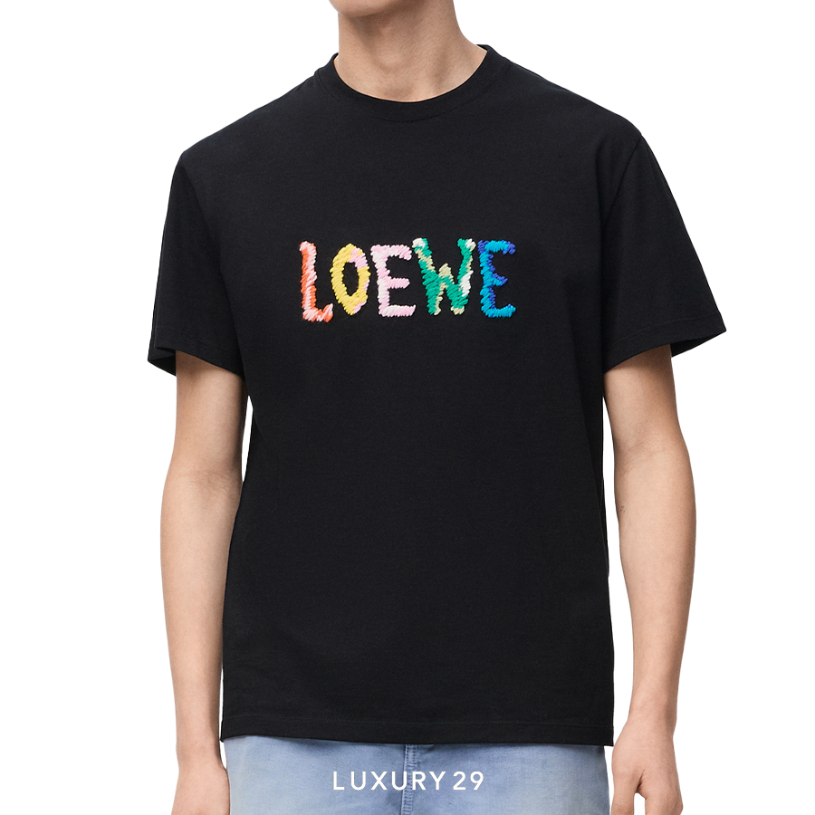 Black t-shirt with colorful 'LOEWE' logo worn by a person on a white background