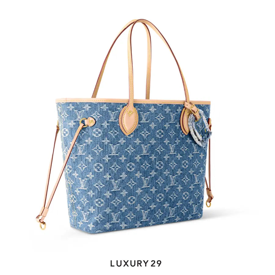 Blue patterned handbag with tan handles on a white background