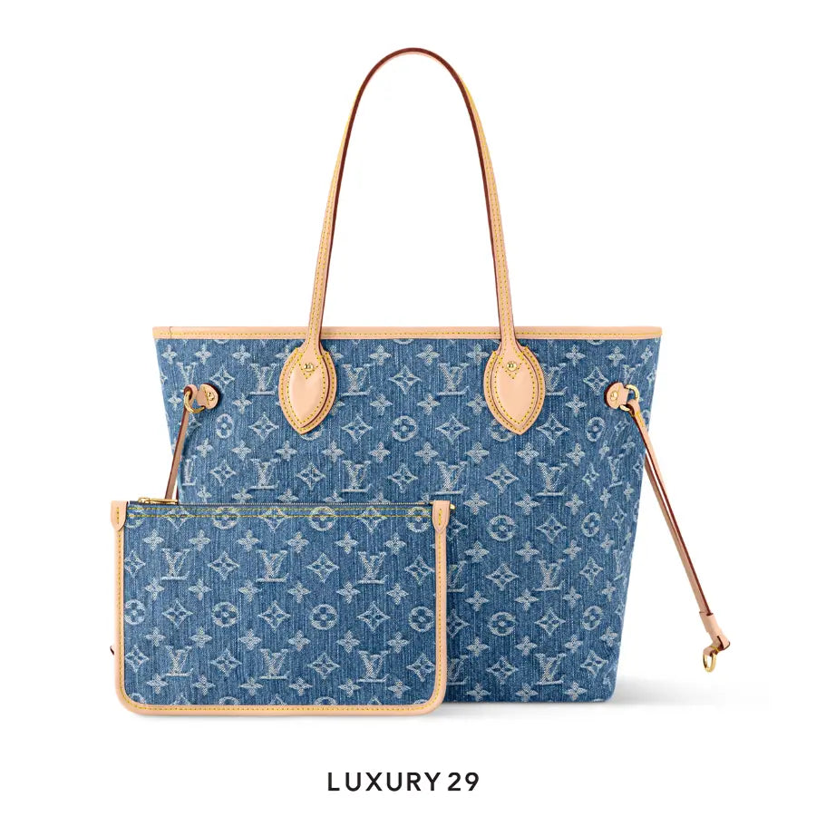 Blue denim handbag with tan leather accents on a white background