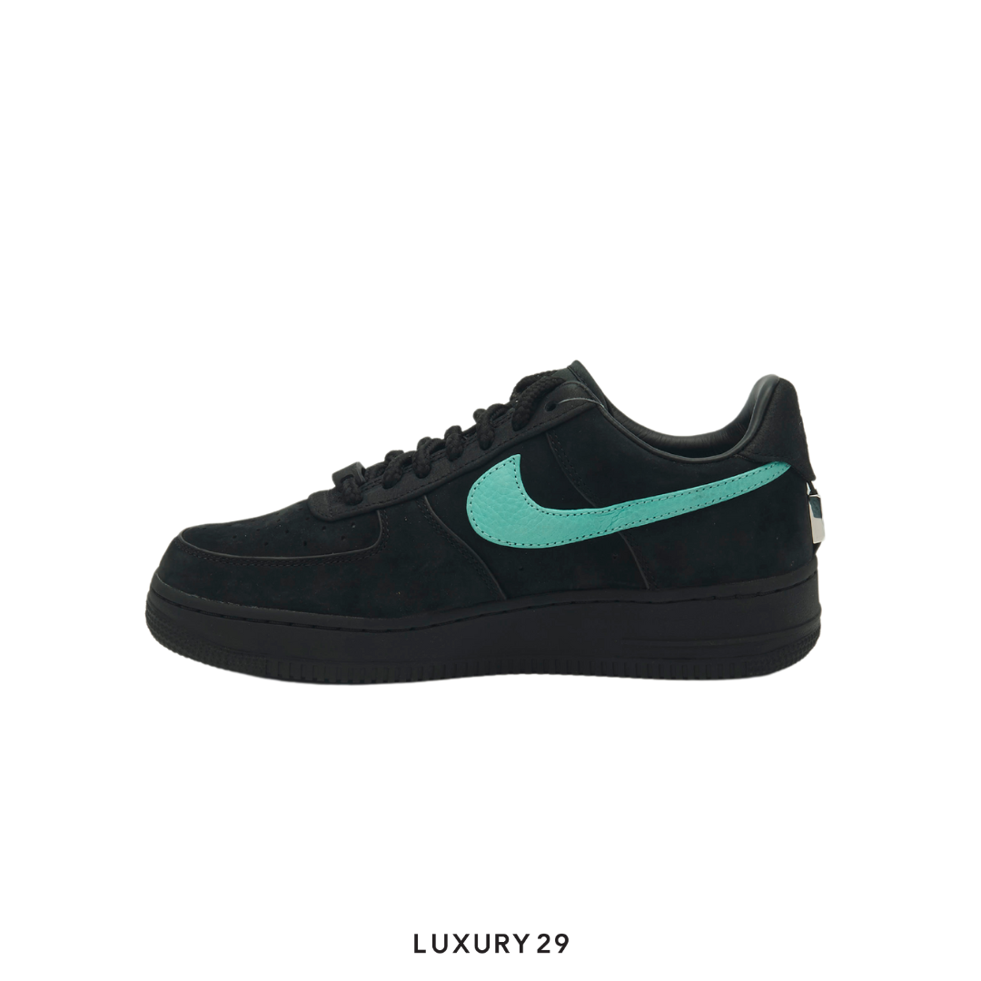 Black sneaker with a green swoosh logo on a white background