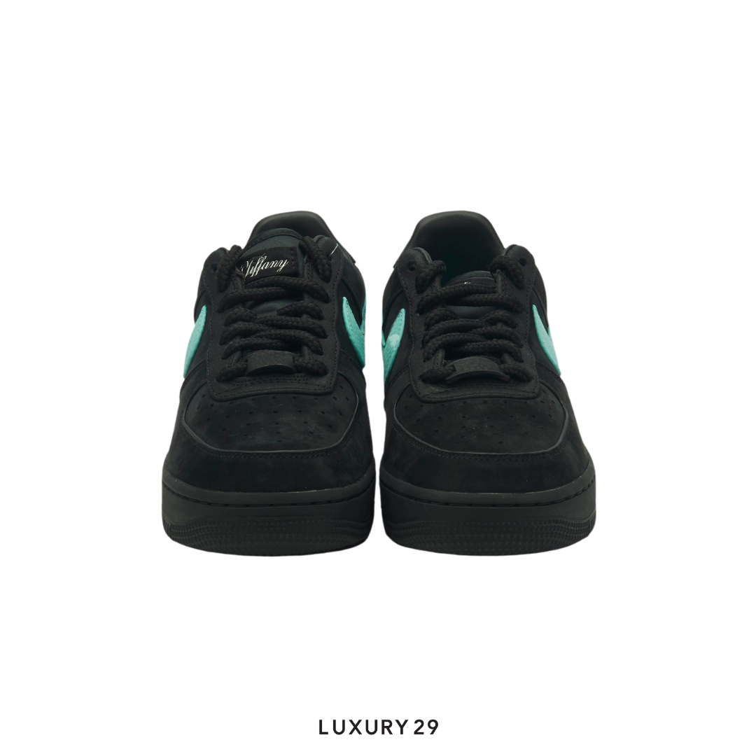 Black sneakers with green accents on a white background