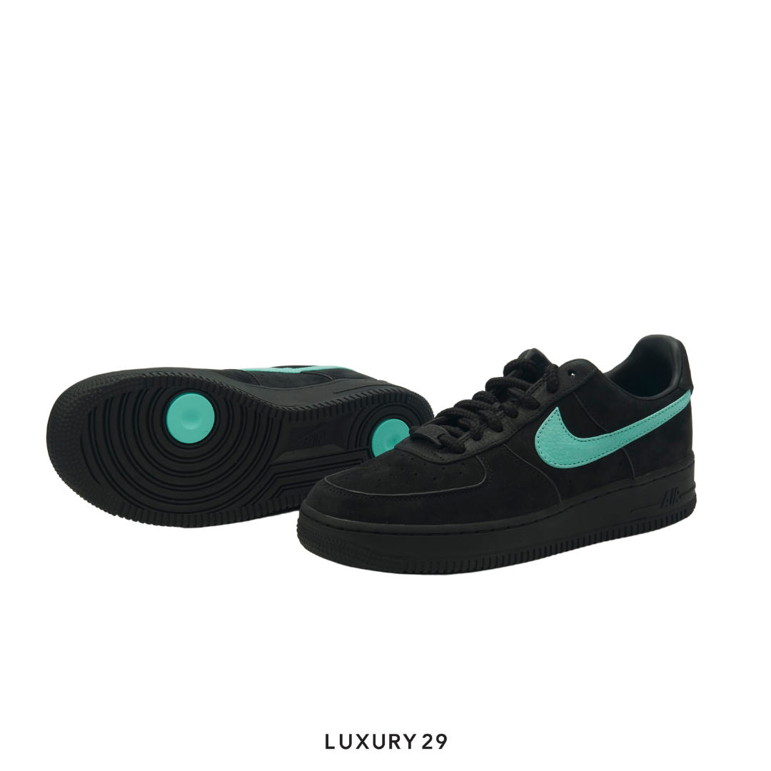 Black sneakers with teal accents on a white background