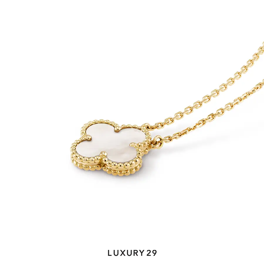 Gold necklace with a clover-shaped pendant on a white background