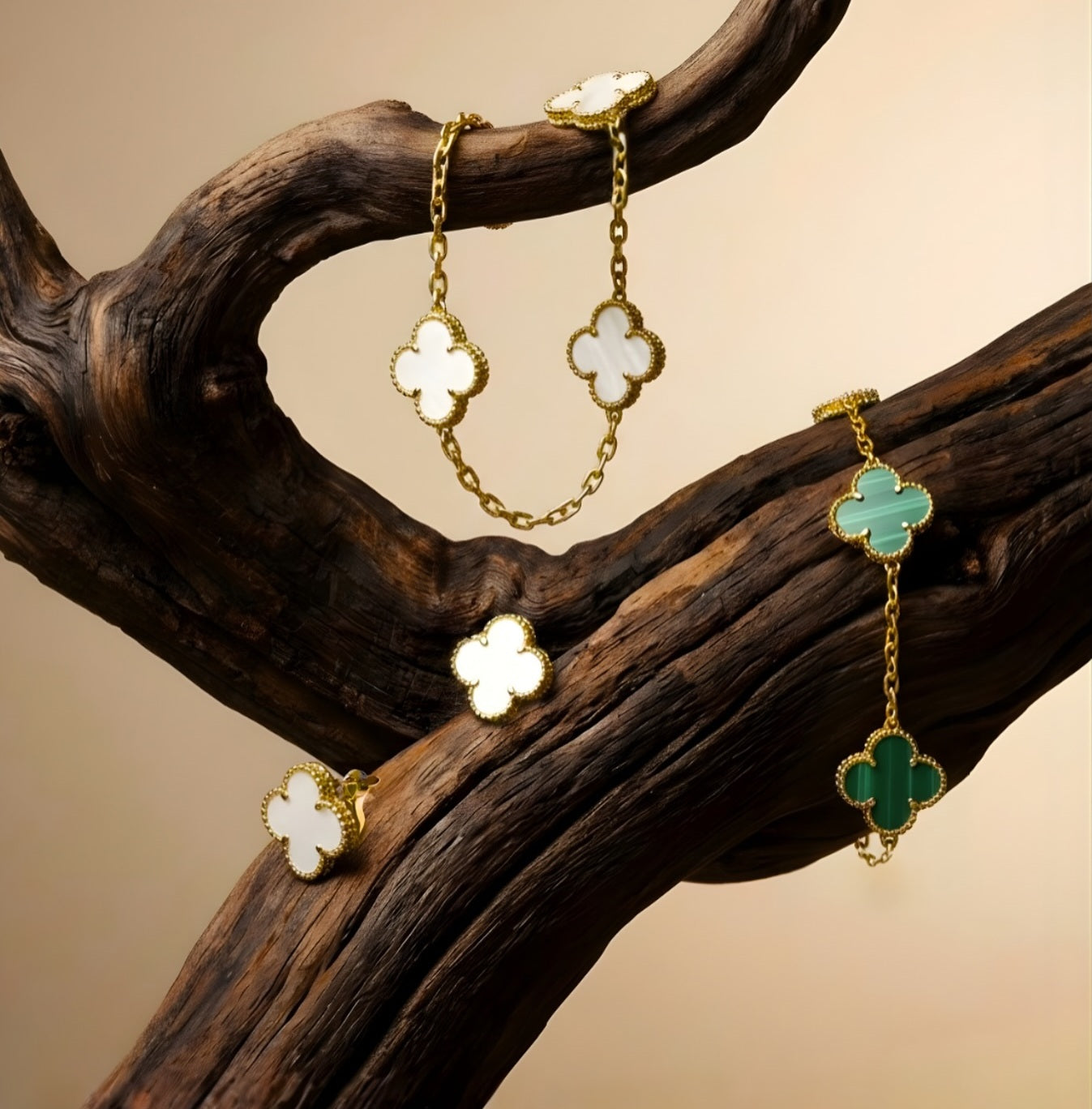 Gold earrings with clover-shaped charms on a wooden branch